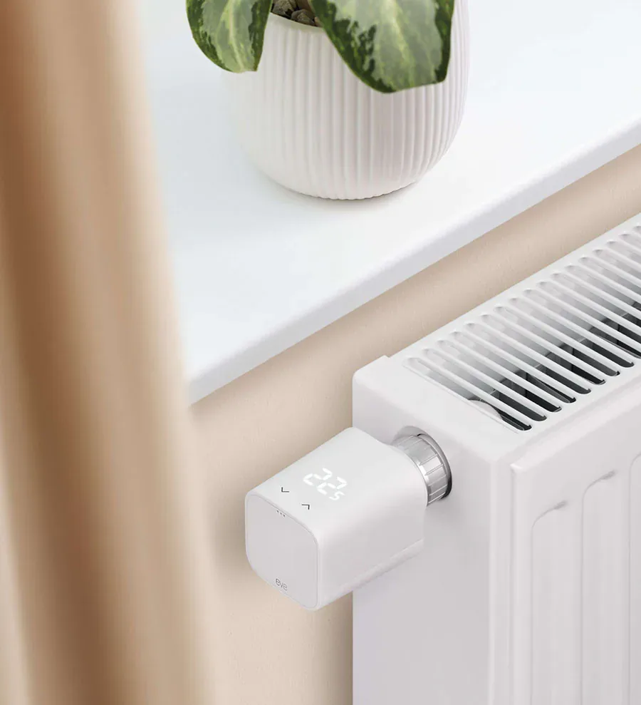 Fifth-generation Eve Thermo attached to a radiator, with its touch arrows and temperature display visible