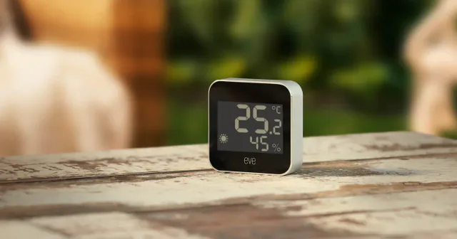 Eve Weather on an outdoor ledge, showing temperature, humidity and a sunny-weather icon