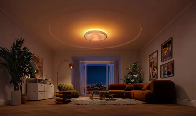 Govee Ceiling Light Ultra mounted above a living room, showing a warm patterned face and a yellow ceiling halo