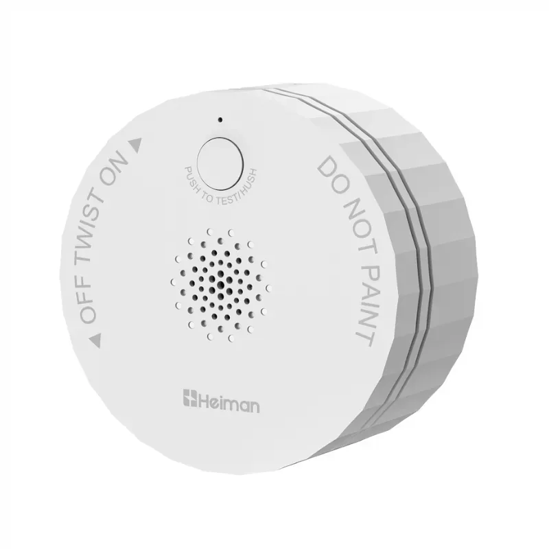 Round white Heiman S1-M smoke alarm with a front test button and sounder holes