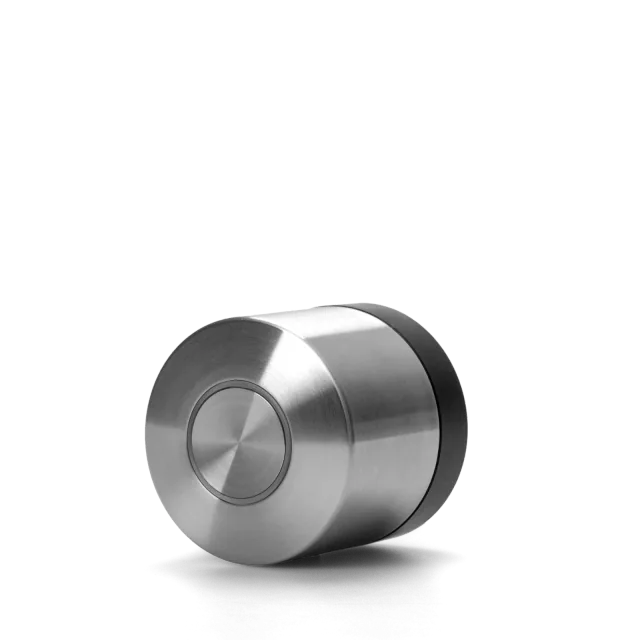 Stainless-steel Nuki US deadbolt retrofit motor with a black base ring