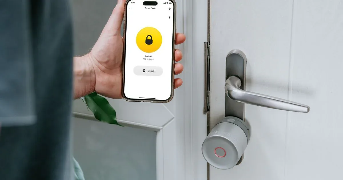 Yale Linus Smart Lock L2 Lite on an interior door beside the Yale Home app