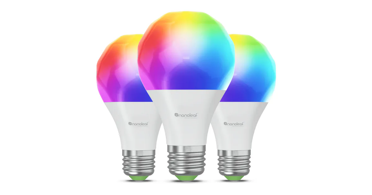 Three Nanoleaf Essentials Matter A19 bulbs with faceted tops lit in rainbow colors and green-ringed E26 bases, on a white background